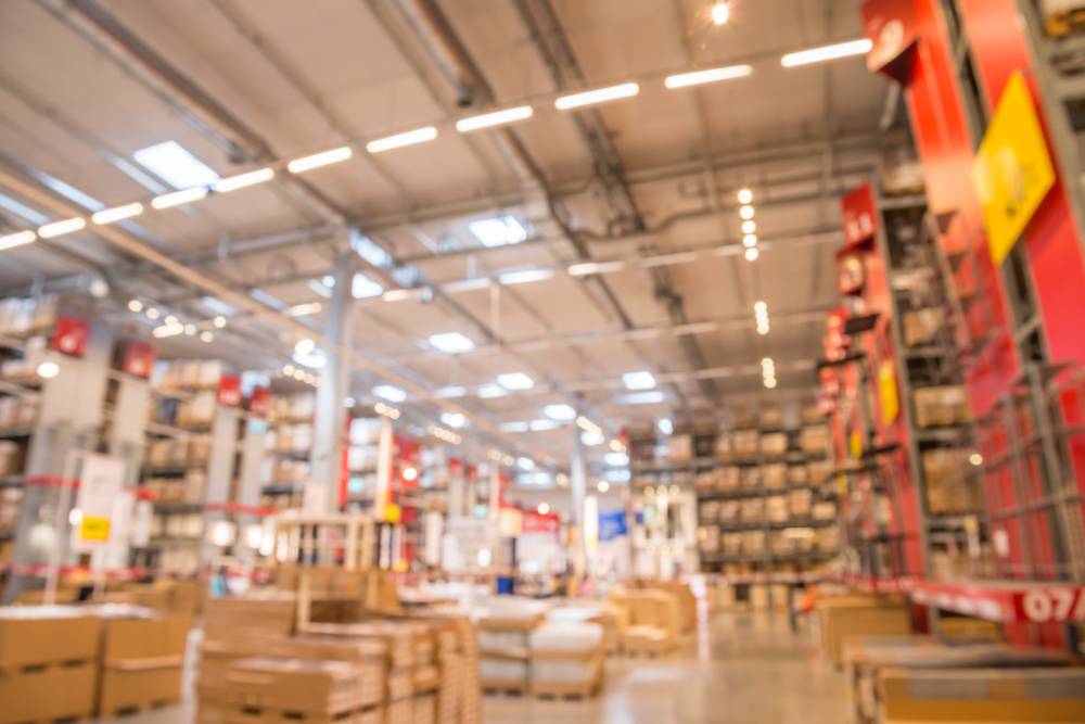 Abstract blurred boxes on rows of shelves in big modern warehouse background