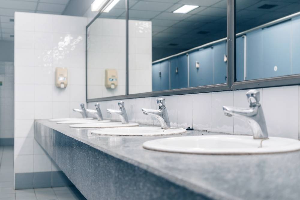 Public toilet and Bathroom interior with white wash basin and sink or lavatory, Close-up of the wash bowl and basin with the stain dirty in the toilet.
